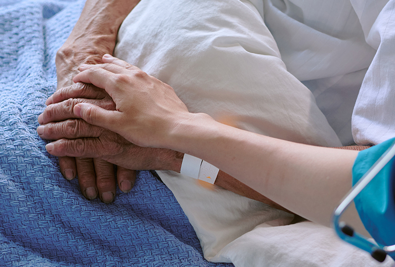 paziente a letto e mano di professionista sanitario