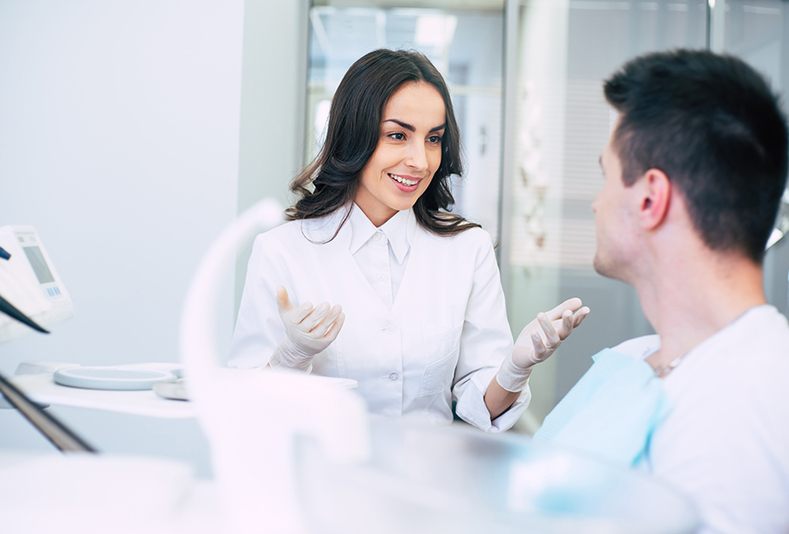 Dentista che parla con il suo paziente