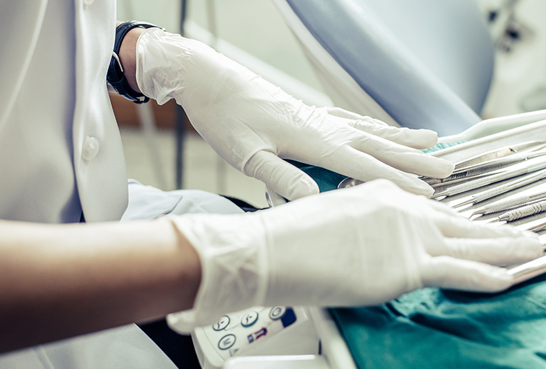 Primo piano di mani di un dentista con i guanti 