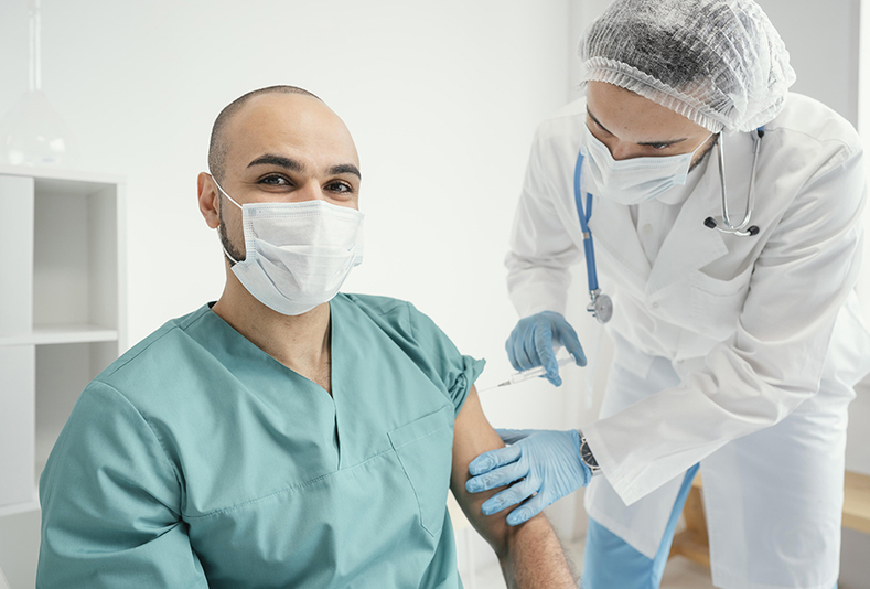 Medico che fa un vaccino ad un suo collega 
