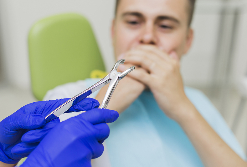 uomo dal dentista che si copre la bocca per paura