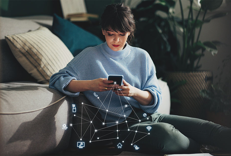 Donna che controlla riunito da smartphone dal divano di casa