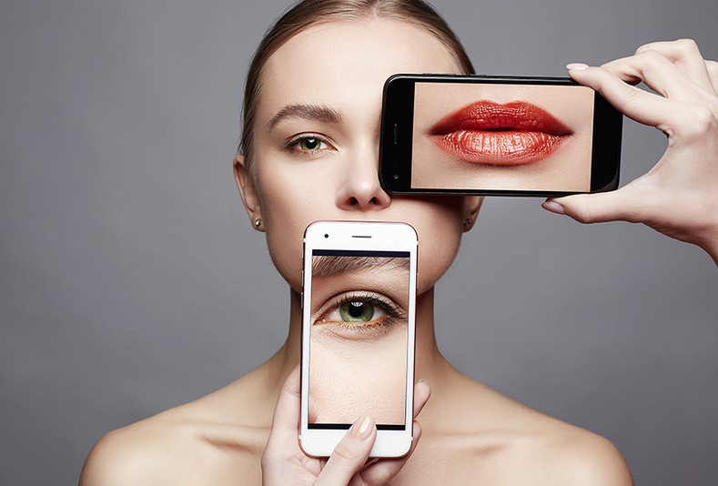 Donna con parti del volto su smartphone