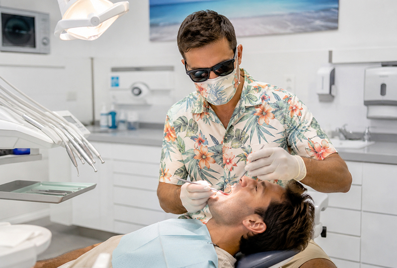 Dentista con camicia a fantasia estiva in studio