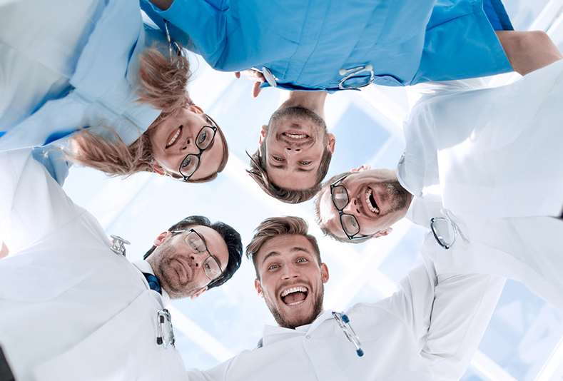 Medici disposti a cerchio che sorridono