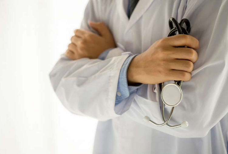 Primo piano di braccia conserte di medico con camice