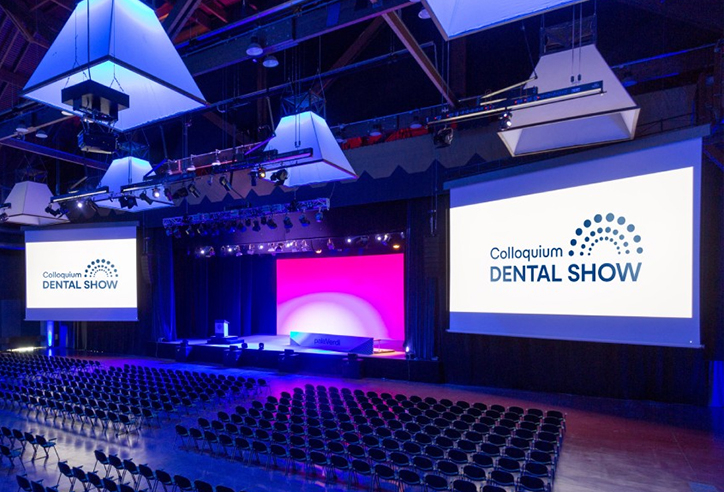 Colloquium DENTAL SHOW sala congressi con maxi-schermi con logo di Colloquium Dental Show