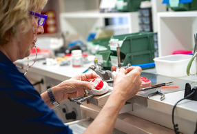 signora che lavora ad una protesi in laboratorio
