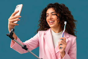Ragazza con smartphone che registra un video educativo con spazzolino in mano