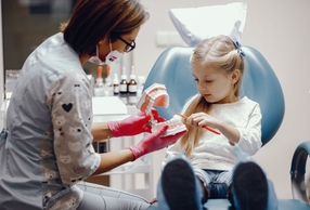bambina con dentista e modellino di dentatura