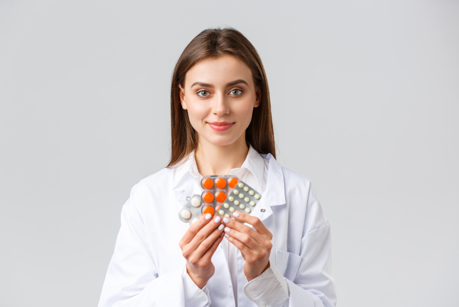 giovane dottoressa tiene in mano blister di farmaci