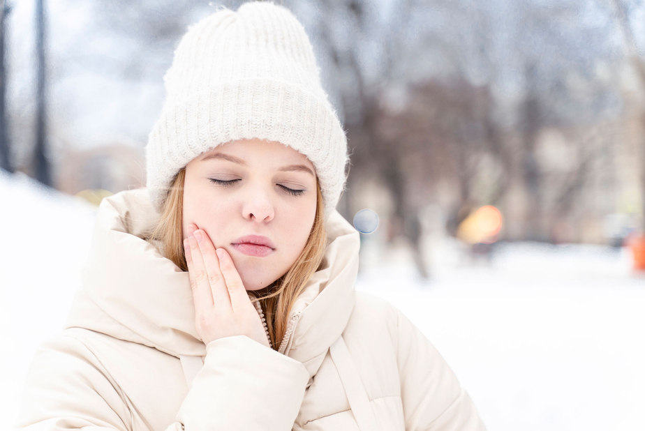 Freddo e salute orale: le cose che non sapevi Donna sulla neve con mal di denti