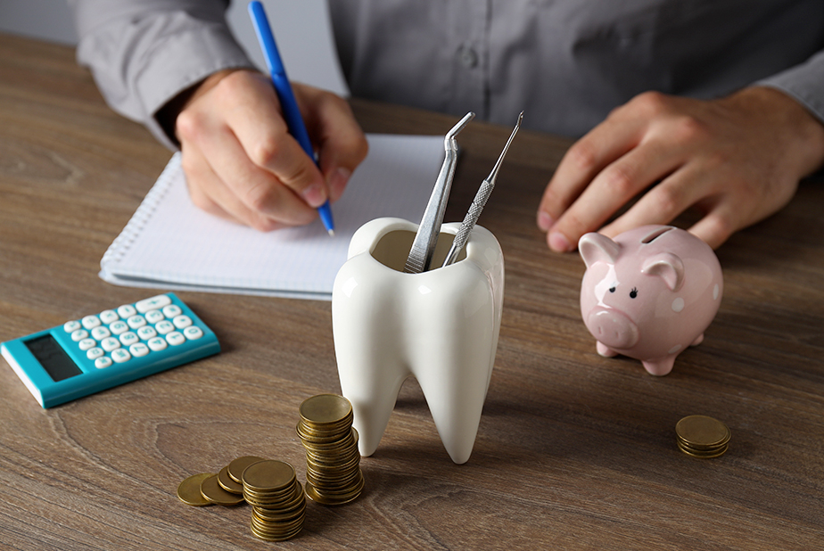 IVA agevolata al 5% per DPI: resta in vigore anche dopo l'emergenza Covid Scrivania con portapenne a forma di dente, calcolatrice e risparmi con salvadanaio