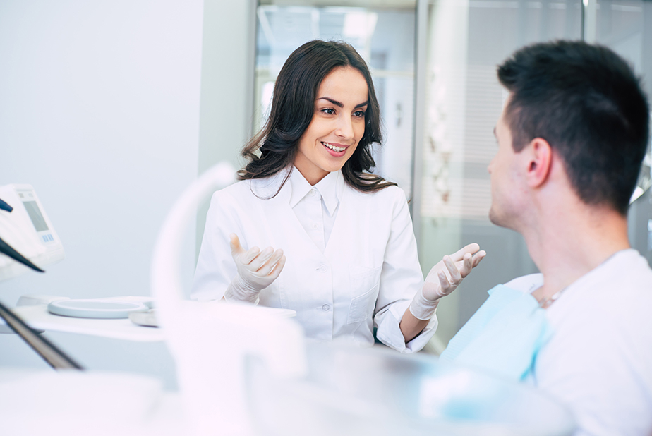 Igiene orale e parodontite: motivare il paziente basta davvero? Dentista che parla con il suo paziente