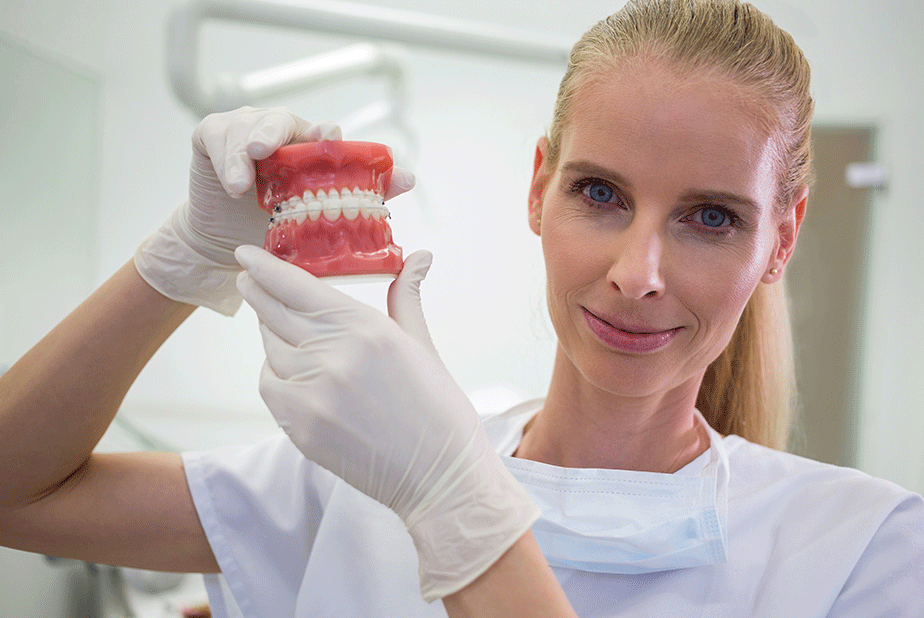 Protesi fisse e ansia: miglioramenti psicologici e qualità della vita medico con dentiera in mano