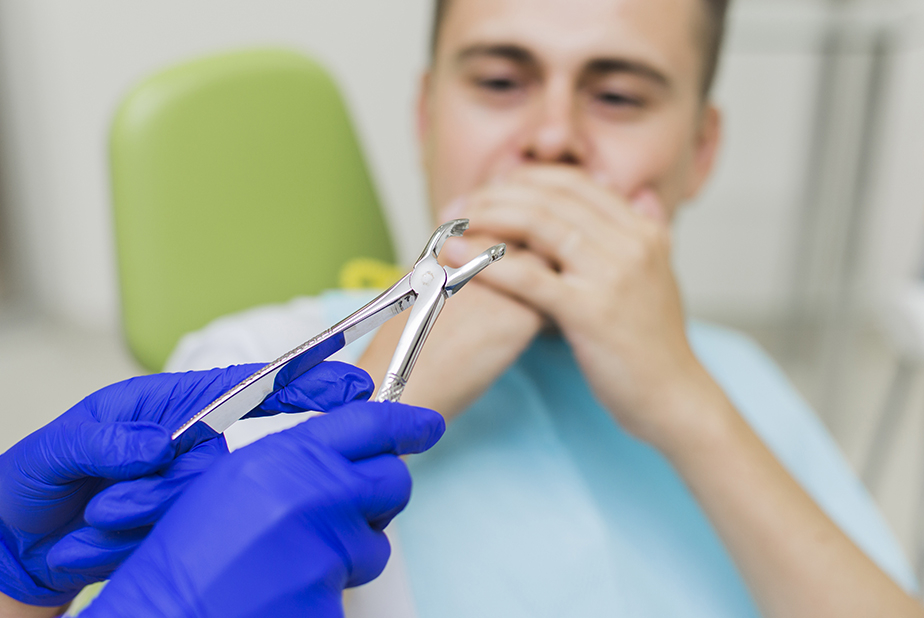 Le aspettative dei pazienti sulla rimozione dei denti del giudizio uomo dal dentista che si copre la bocca per paura
