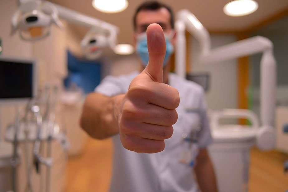 Professionista in studio con il pollice alzato in segno di ok