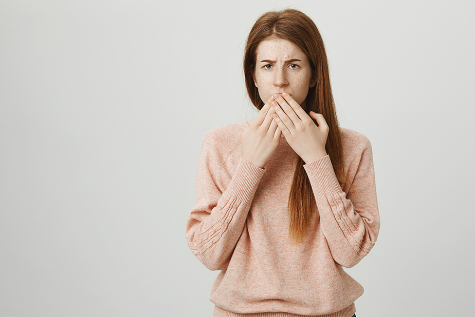 donna con mani sulla bocca