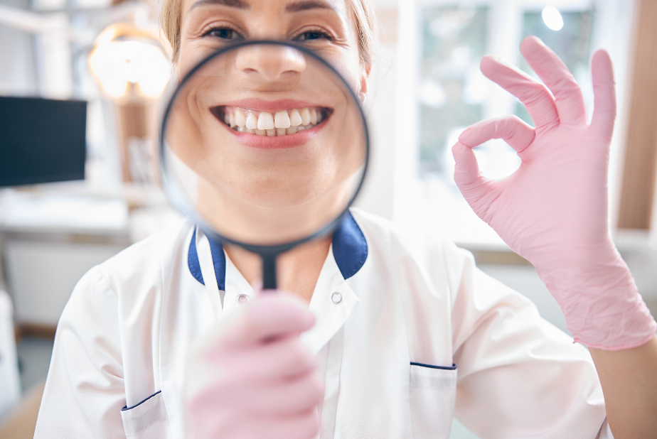 Il Mese della Prevenzione Dental compie 46 anni medico con lente di ingrandimento su sorriso
