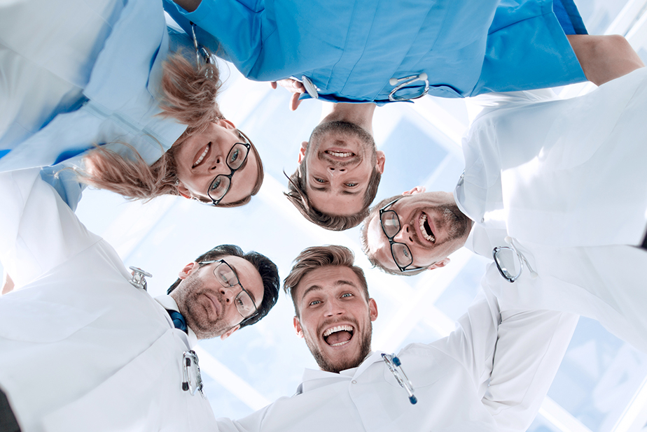 L'80% dei medici è soddisfatto del proprio lavoro Medici disposti a cerchio che sorridono