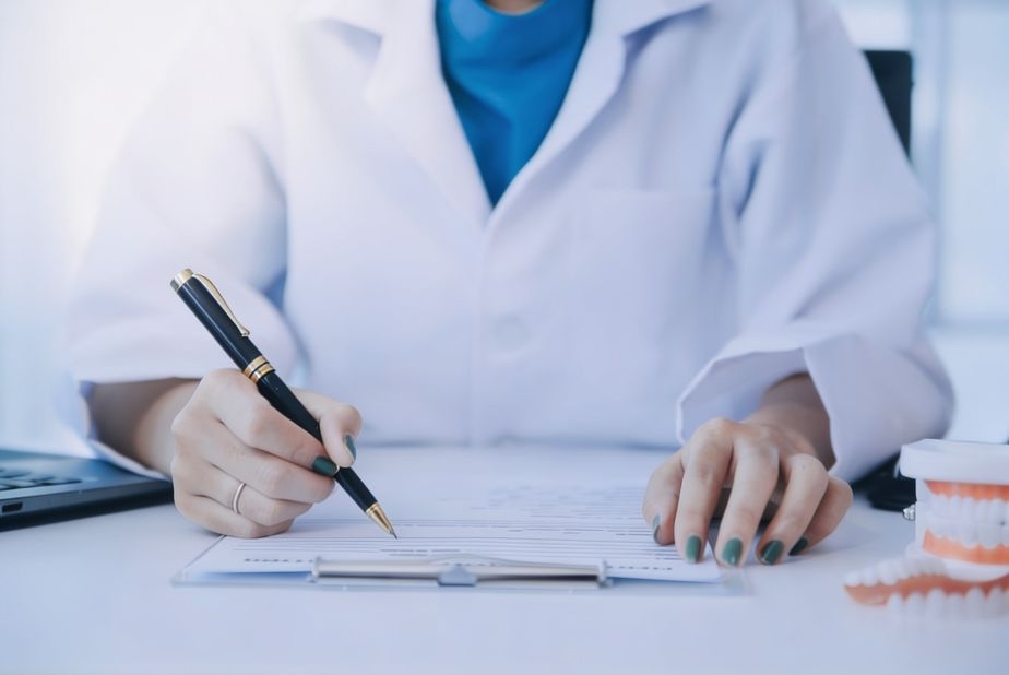 Primo piano su mani di medico che scrivono