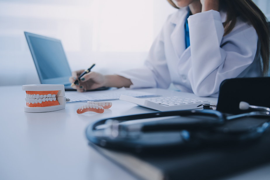 AIO: una guida rapida per il titolare di studio odontoiatrico medico con modellino di dentatura e pc